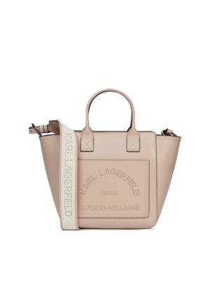 Beżowa skórzana torba typu tote z dwoma uchwytami, przednią kieszenią oraz szerokim regulowanym paskiem na ramię z napisem „Karl Lagerfeld”.