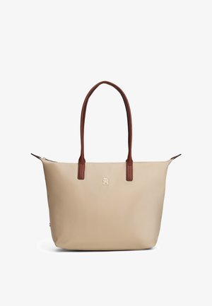 Beige mulepose med lange brune håndtag, lille gyldent logo i midten og lynlås i toppen.