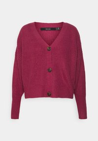 Pink knitted cardigan featuring a V-neck, oversized fit, and five round brown buttons down the front. Cropped length with ribbed texture.