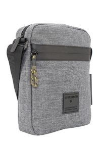 Šedá látková taška přes rameno s černými koženými detaily, se zipem a nastavitelným popruhem. Má texturovaný povrch a logo nášivku.