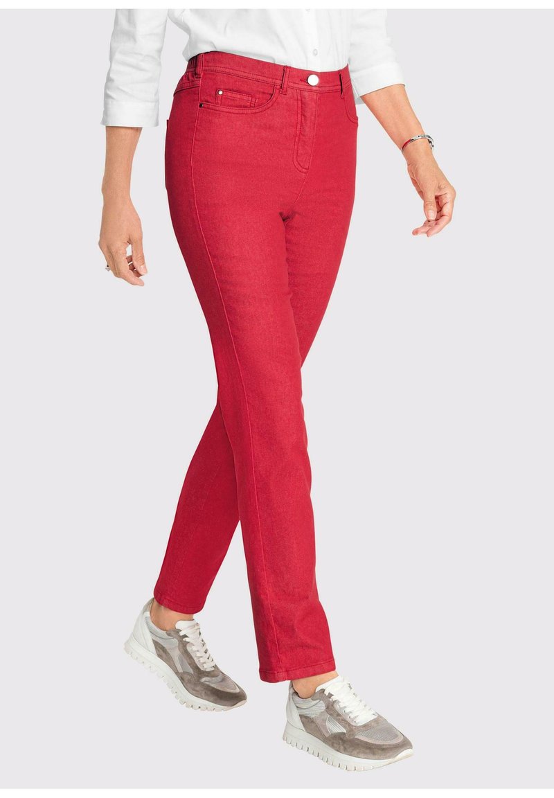 Rode denim jeans met een slim fit, voorzien van vijf zakken, een knoopsluiting en naadloze stiksels. Gecombineerd met grijze sneakers.