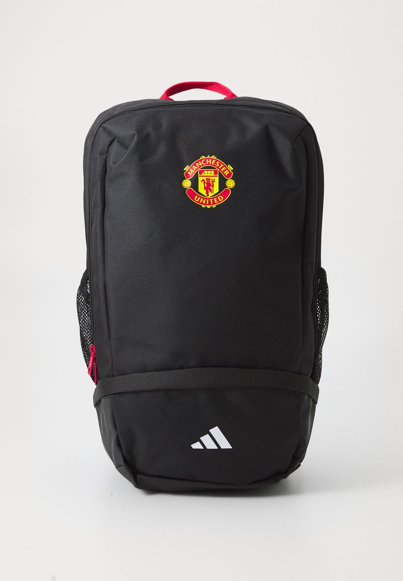 Svart ryggsekk med røde detaljer, med Manchester United-logoen på fronten, netting side lommer, og Adidas-logoen nederst.