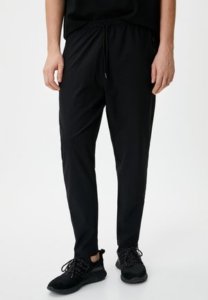 Sorte atletiske bukser med elastisk talje, justerbar snøre og sidelommer. Glat stof og tapered ben design for komfort.
