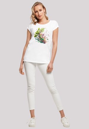 Weißes kurzärmliges T-Shirt mit einem bunten Blumenmotiv, das grüne Blätter und rosa Blumen in einer kreisförmigen Anordnung zeigt.