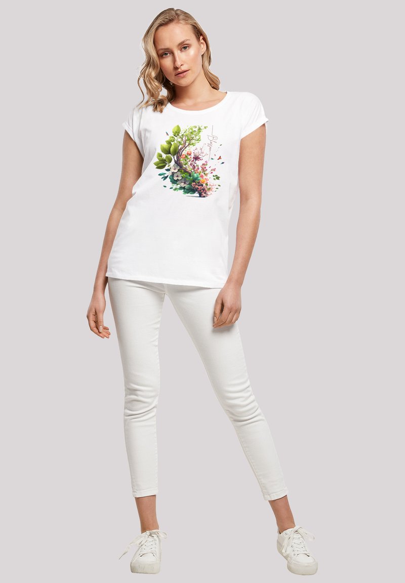 Weißes kurzärmliges T-Shirt mit einem bunten Blumenmotiv, das grüne Blätter und rosa Blumen in einer kreisförmigen Anordnung zeigt.