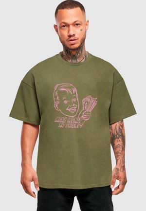 Olivově zelené oversized tričko vyrobené z bavlny, se růžovou grafikou postavy držící peníze a textem "VYDĚLEJ PENÍZE, ŽÁDNÍ PŘÁTELÉ."