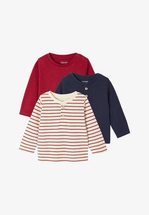Three long-sleeve shirts: one red, one navy, and a cream with red stripes. The striped shirt features a buttoned neckline. Soft cotton material.