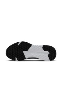 Semelle de chaussure de sport en noir et blanc, présentant une surface en caoutchouc texturée, de profonds motifs de bande de roulement et un intersemelle en plastique avec des motifs géométriques.
