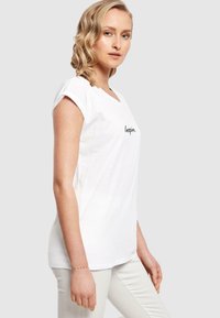 Hvid bomulds t-shirt med V-udskæring og korte ærmer, prydet med ordet "Inspire." i sort på fronten. Glat tekstur, afslappet pasform.