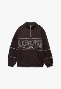 Ciemnobrązowy sweter z wysokim kołnierzem i pół-zamkiem. Posiada biały napis "HANNOVER" oraz grafikę gór, a także kontrastowe paski.