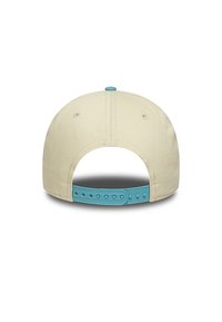 Gorra de béisbol beige con una correa ajustable de plástico azul, que presenta un diseño de color sólido y agujeros de ventilación a los lados.