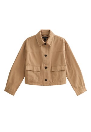 Veste courte couleur beige avec col, manches longues, fermeture à boutons sur le devant et deux grandes poches à rabat à la taille.