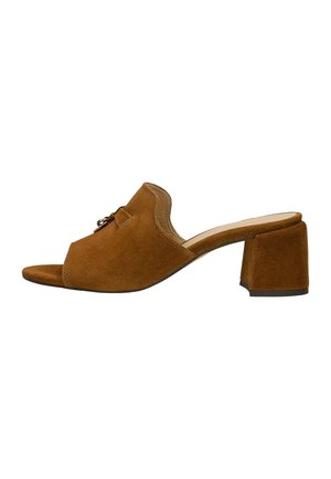 Mule en daim marron à bout ouvert avec talon bloc et petit accent métallique décoratif sur le dessus.