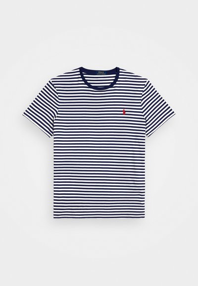 T-maica prugasta u mornarsko plavoj i bijeloj boji s kratkim rukavima i okruglim izrezom. Ima mali crveni logo na lijevoj strani grudi. Materijal je pamuk.