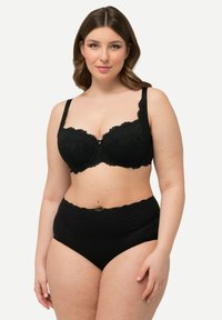 Reggiseno nero in pizzo con ferretto, caratterizzato da un motivo floreale, spalline regolabili e un dettaglio di bottone decorativo al centro. Inclusi slip neri a vita alta.