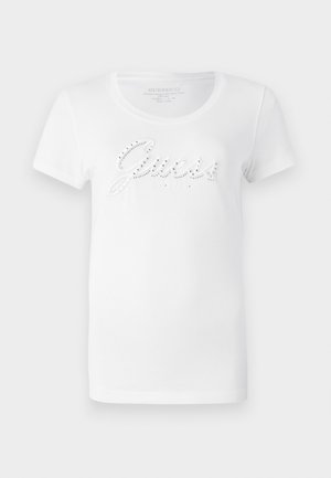 White short-sleeve t-shirt featuring raised "Guess" logo embellished with rhinestones, round neckline, and soft cotton fabric.