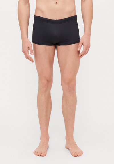 Șorturi de baie negre dintr-un material neted și elastic, de lungime medie, până la mijlocul coapsei, cu un design simplu și adaptat. Au un branding minim pe lateral.