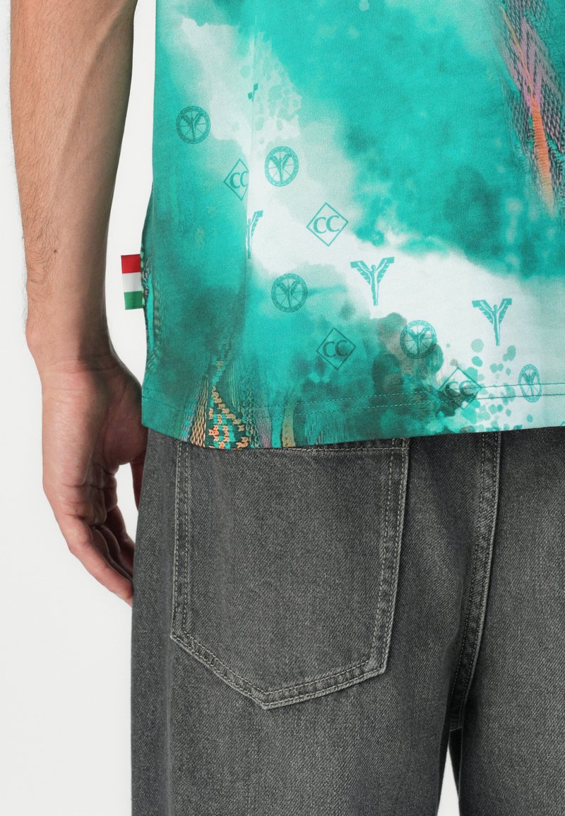 Türkiser kurzärmeliger Hemd mit abstrakten Mustern und Logos, einem mehrfarbigen Saum und einem kleinen ungarischen Flaggen-Detail an der Seite.