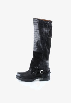 Botte noire mi-mollet en cuir lisse et texturé crocodile, détail de sangle à boucle près du talon, talon bas empilé.