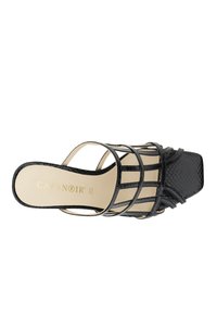 Zwarte hielsandalen met een gegraveerd patroon, open ontwerp met gekruiste banden, vierkante neus en een beige binnenzool met gouden branding.