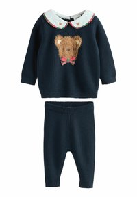 Marineblauwe trui met een fluffy berengezicht ontwerp en een geruite strik, gecombineerd met bijpassende marineblauwe gebreide broek. Beschikt over een witte kraag met berenmotieven.