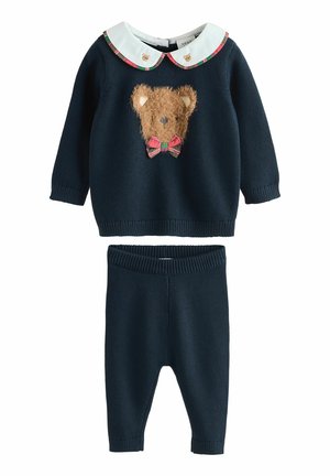 Maglione blu navy con design di un viso di orso peloso e fiocco a quadri, abbinato a pantaloni a maglia blu navy. Presenta un colletto bianco con motivi di orsetti.