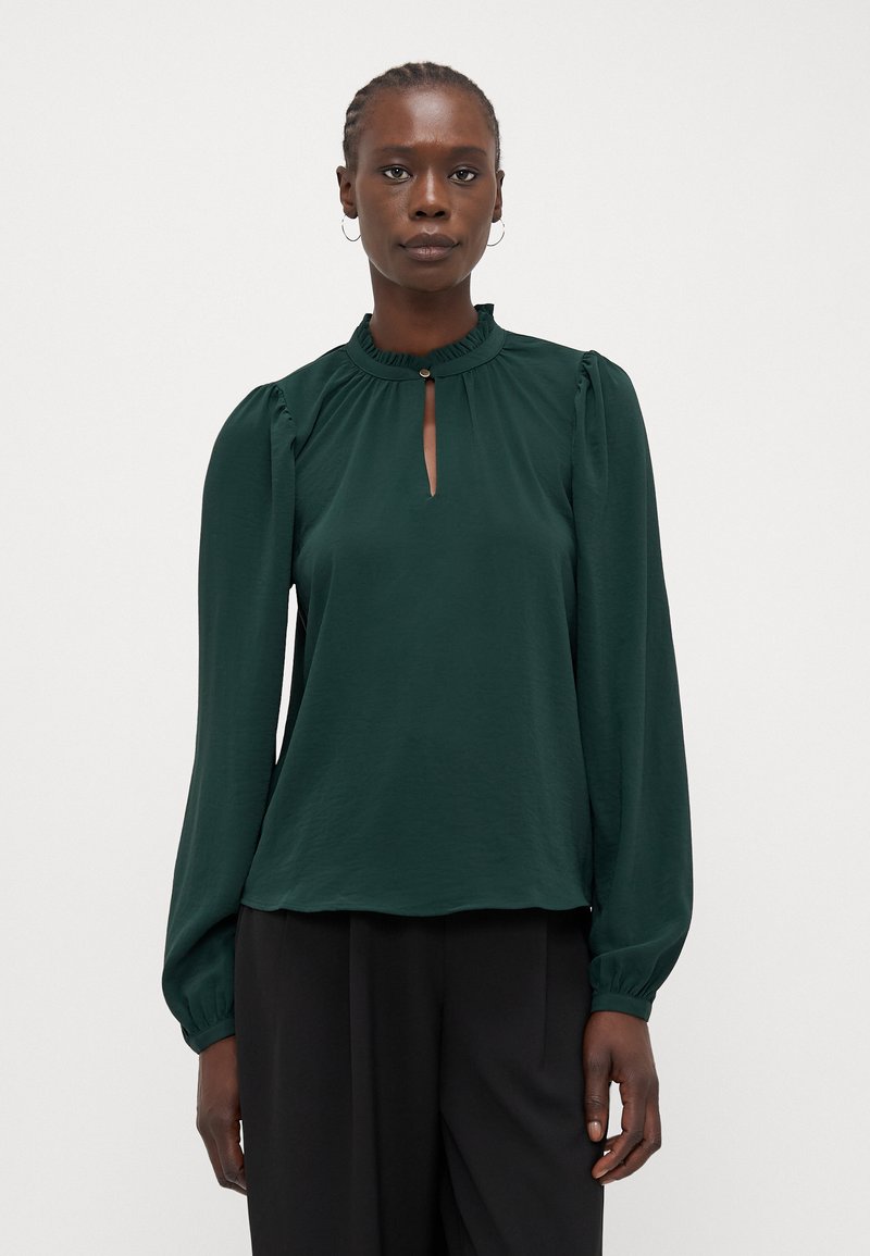 Forest green blouse with long, puffed sleeves, a high, ruffled neckline, and a keyhole opening. Smooth fabric, lightweight texture.