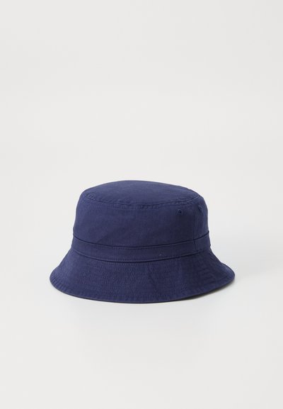 Sombrero tipo cubo de algodón azul marino con una corona redonda y suave y un ala ancha, que presenta una banda cosida y dos ojales en los lados para ventilación.