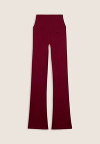 Pantaloni yoga a vita alta, di un rosso intenso, con gambe svasate, cucitura sul retro ben visibile e dettagli di tasca cuciti in modo sottile, su sfondo neutro.
