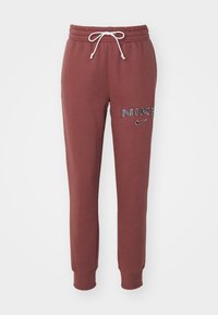 Burgundy joggers i mjukt material, med elastisk midja och dragsko, ribbade mudd och Nike-logotypdetaljer på sidan.