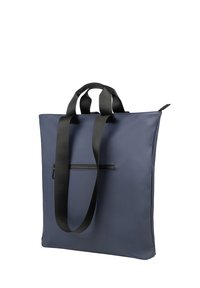 Sac fourre-tout bleu marine en matériau lisse, doté de deux poignées noires, d'une poche zippée à l'avant et d'un design minimaliste.