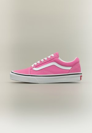 Basket rose à tige basse avec lacets blancs, bande latérale blanche et semelle épaisse blanche bordée de noir sur fond neutre.