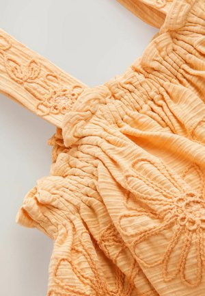 Abito arancione, con tessuto texturizzato, caratterizzato da arricciature e ricami floreali sulle spalline larghe, realizzato in un materiale morbido che crea un aspetto arricciato.