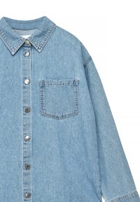 Svetlo modra jeans srajca z ostrim ovratnikom, gumbi na sprednji strani, dolgimi rokavi in enim žepom na prsih. Tkanina s teksturo in vidnimi šivi.