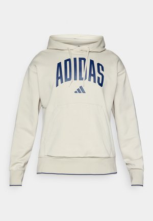 Hanorac de culoare crem cu glugă, dotat cu o buzunar frontal și un logo „ADIDAS” mare, de culoare bleumarin, din țesătură texturată și cu manșete și margine cu nervuri.
