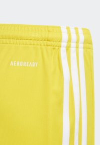 Gelbe Sportshorts mit elastischem Bund, weißen drei Streifen im Detail und "AEROREADY" in weißer Schrift aufgedruckt.