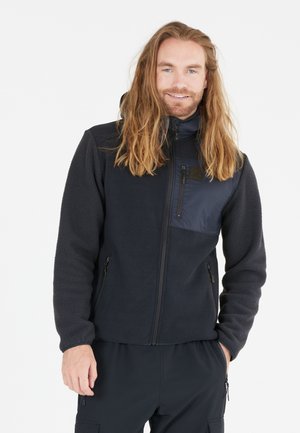 Navy fleece jacket with a smooth nylon chest pocket, zippered front, and side pockets; features a high collar and relaxed fit.