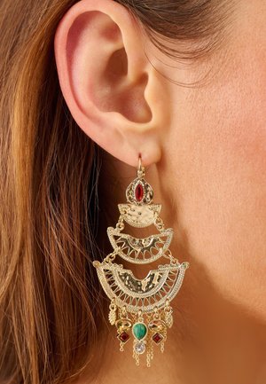 Gold-tone chandelier earrings with intricate filigree design, featuring red, green, and clear stone accents and hanging chain details.