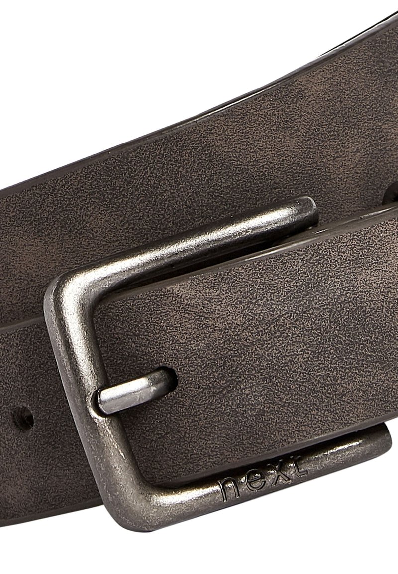 Bruine leren riem met een gestructureerde afwerking en een gepolijste metalen gesp gegraveerd met "next." Kenmerkt zich door een klassiek ontwerp en robuuste bevestigingsmaterialen.