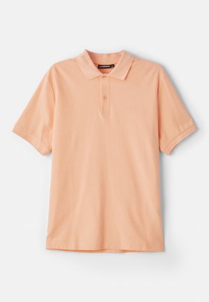 Polo en pêche en coton. Il présente un col classique, des manches courtes et un logo discret sur la poitrine. Texture douce, design simple.