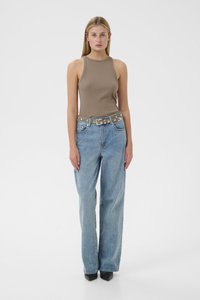 Brown ribbed tank top, high-waisted blue jeans, gray belt with silver accents, black heeled shoes, model standing against a white background.