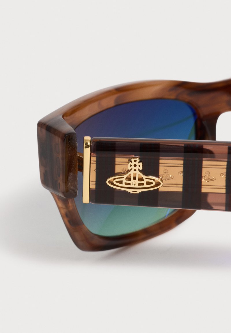 Brown tortoiseshell sunglasses with blue-green lenses and gold logo emblem on the striped temple arm.