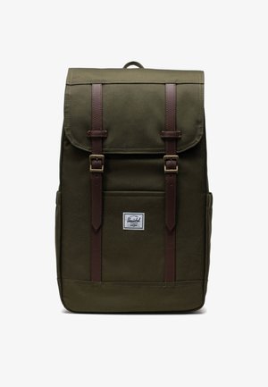 Zelený látkový batoh s hnedými koženými popruhmi a kovovými prackami, predná vrecko a biele logo značky Herschel umiestnené v strede na prednej strane.