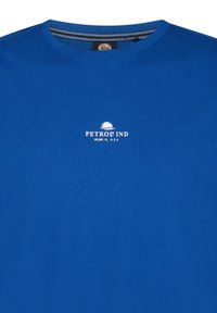 Modrá bavlněná trička s kulatým výstřihem a malým bílým logem na hrudi, které zní "PETROL IND MIAMI FL. USA." Hladká textura.