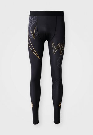 Schwarze Sportsleggings mit einer glatten Textur, die goldene Akzente und ein grafisches Design an den Beinen aufweisen. Elastischer Bund für zusätzlichen Komfort.