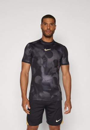 Nike short-sleeve athletic shirt in black with a textured pattern featuring circular shapes; includes a gold logo on the chest.