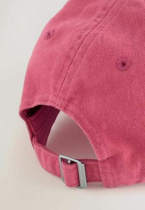 Gorra de béisbol de algodón rosa con tejido texturizado, costuras visibles y una hebilla ajustable plateada en la parte trasera para ajustar el tamaño.