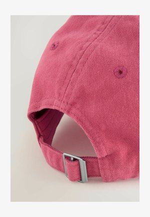 Roze katoenen honkbalpet met gestructureerde stof, zichtbare stiksels en een zilveren verstelbare gesp aan de achterkant voor maatverstelling.