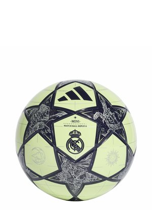Mini-football vert avec un motif d'étoiles noires, comportant des emblèmes et un logo au centre. Texture lisse avec des coutures cousues.