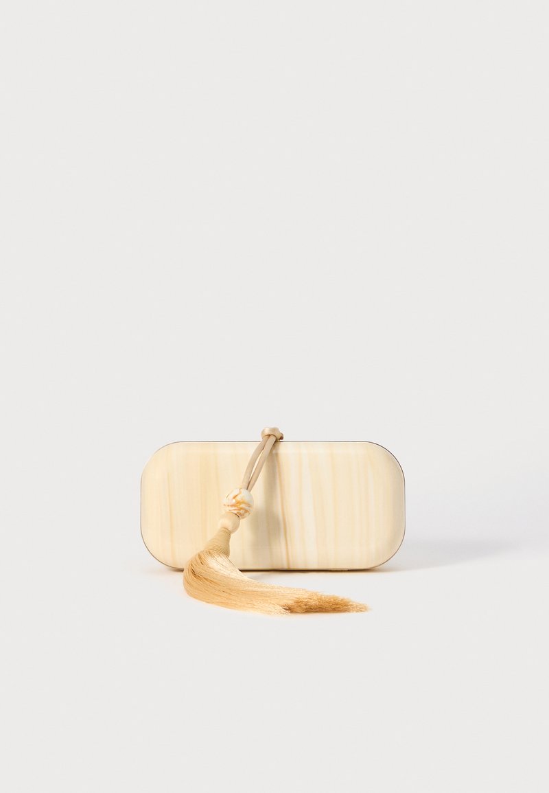 Accesoriu rectangular realizat dintr-un material de culoare deschisă, cu o textură netedă, având o franjură atașată printr-un șnur și o perle decorativă.